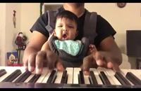 پیانو زدن پدر و خوابیدن بامزه نوزاد در آغوش پدر